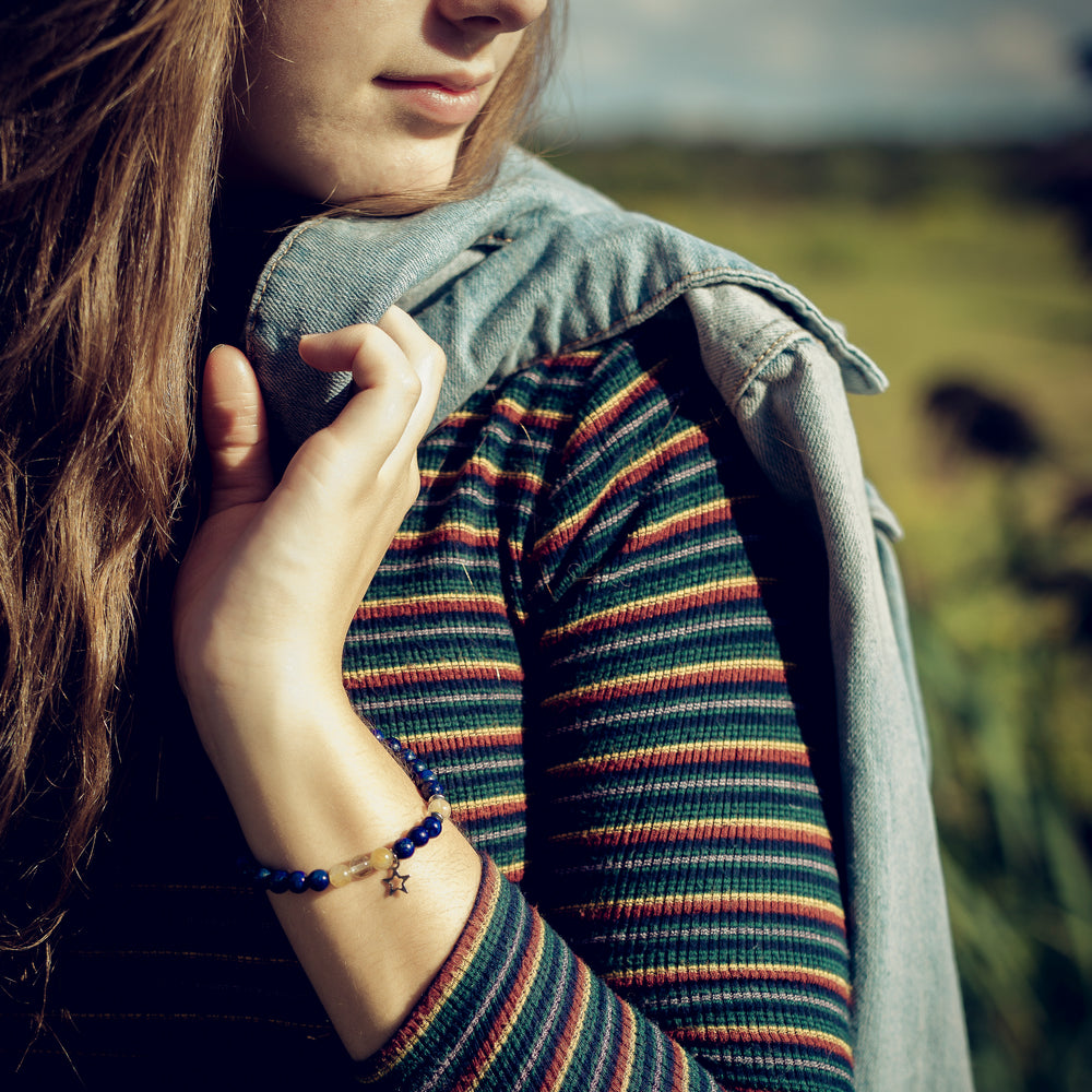 
                  
                    Femme au chandail multicolor à l'extérieur portant le bracelet Obscur de Ovie Bijoux
                  
                