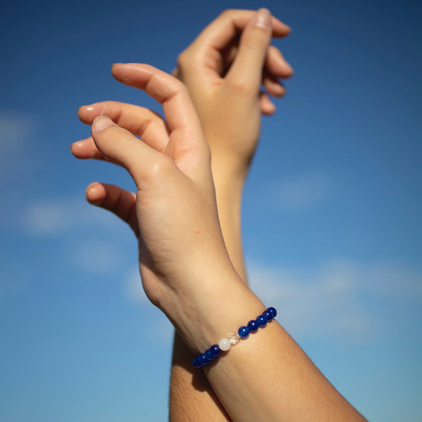 
                  
                    Poignets de femme portant le bracelet aux pierres bleus
                  
                