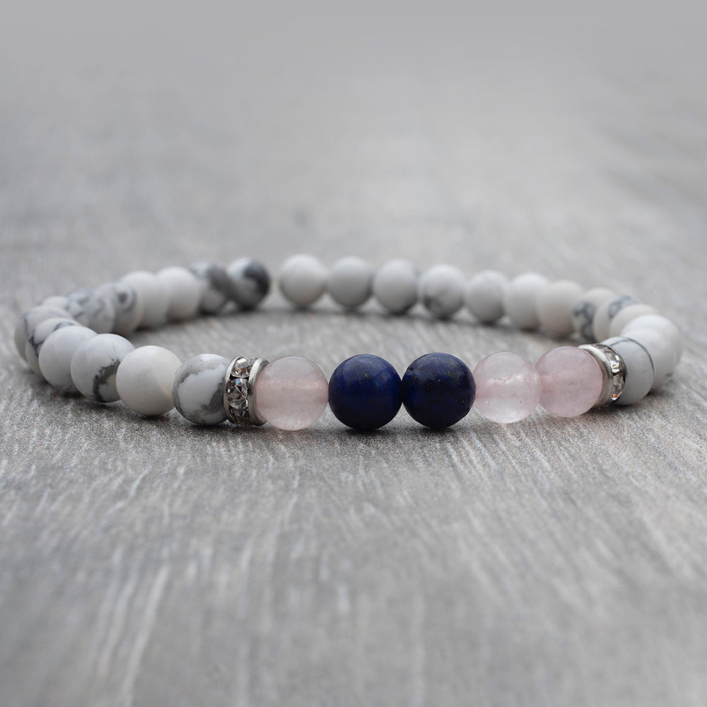 
                      
                        Bracelet élastique fait au Québec avec des pierres fines howlite, quartz rose et lapis lazuli.
                      
                    