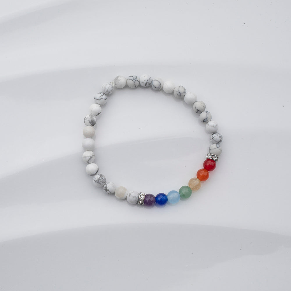 Bracelet de pierres fines aux couleurs de l'arc-en-ciel sur fond blanc