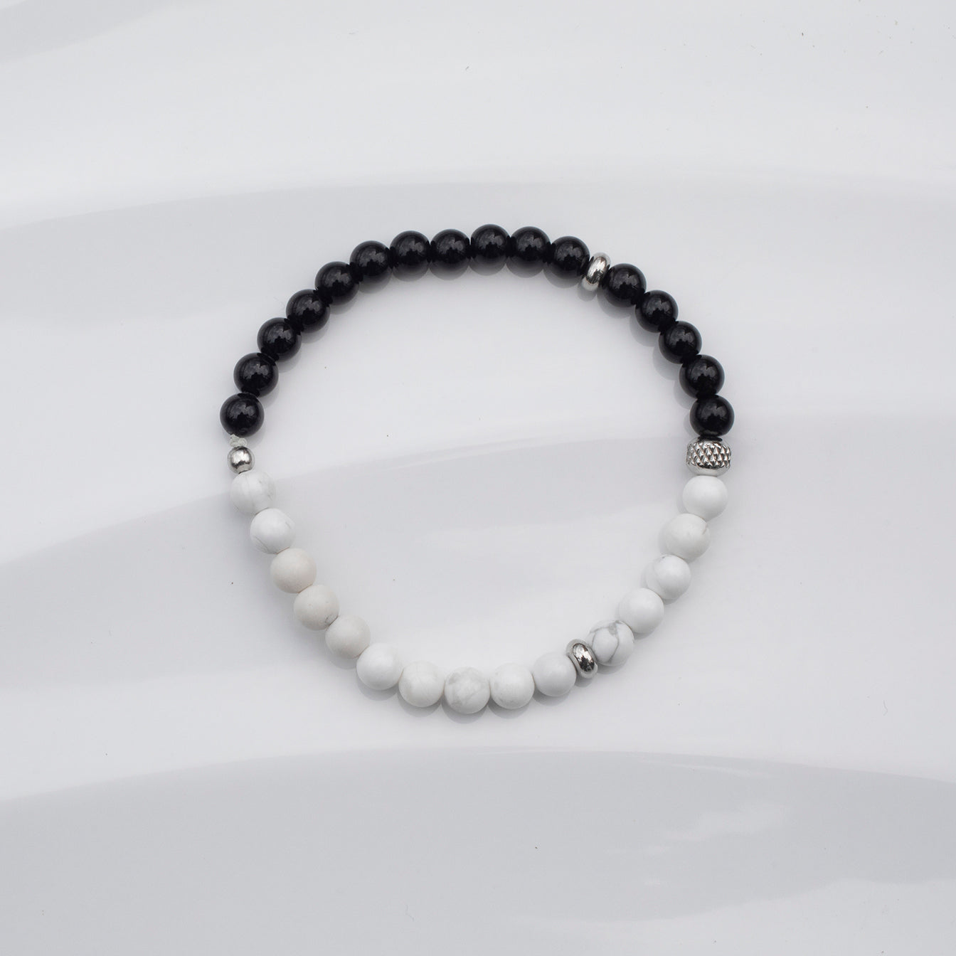 
                  
                    Bracelet Ying Yang -  Garni de pierres fines onyx et howlite sur fond blanc.
                  
                