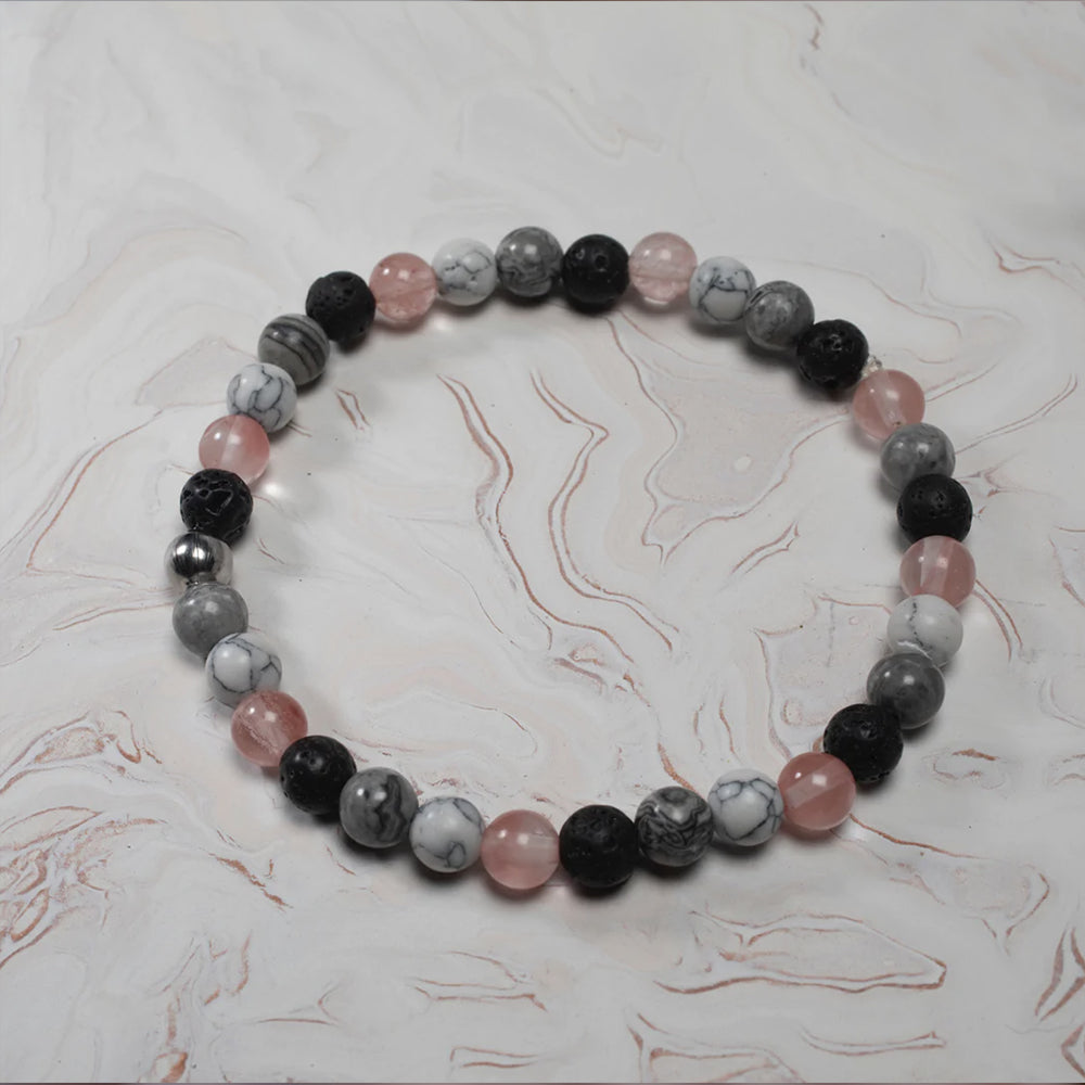 Bracelet Gaïa - Bracelet composé de pierres de quartz, obsidiennes, howlites et volcaniques sur un fond marbré blanc